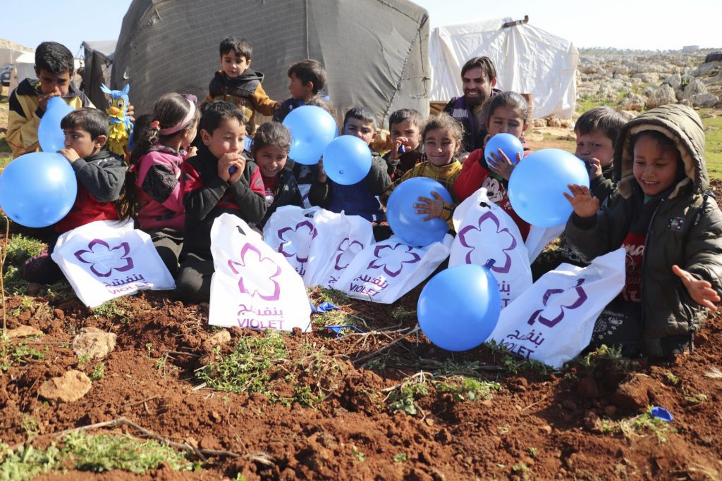 Kinderen spelen met ballonnen in Noordwest Syrie. Vrijwilligers van Violet hebben ze tassen gegeven en houden ze bezig.